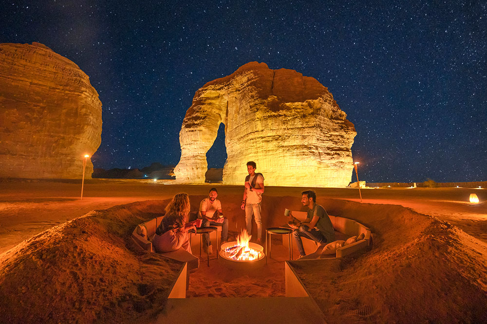 Des personnes font un barbecue la nuit devant la statue de l'Éléphant à AlUla.